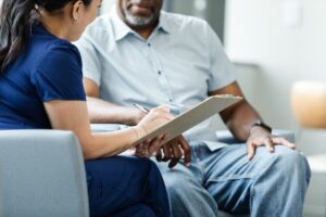 female healthcare professional helps her patient fill out paperwork