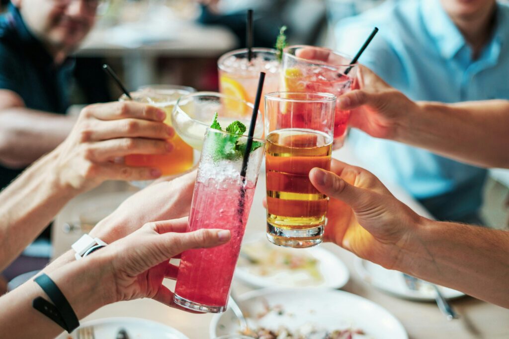 close up of a group of friends with drinks cheers