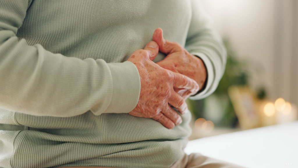 close up of a man holding his stomach sitting down