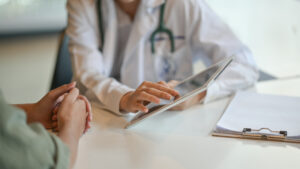 doctor showing a patient some information on a digital tablet