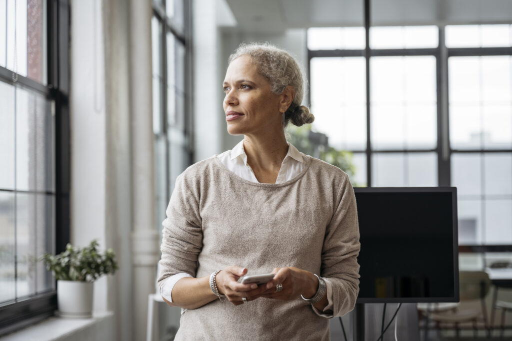 Contemplative woman pausing from text messaging
