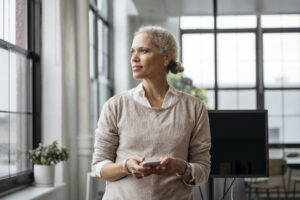 Contemplative woman pausing from text messaging