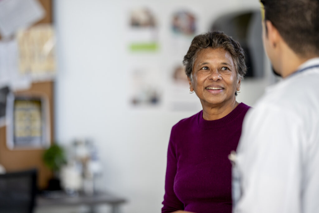 Senior Woman Speaking With Doctor In Clinic