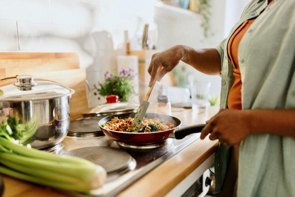 Woman preparing vegetable mix cooked in a frying pan