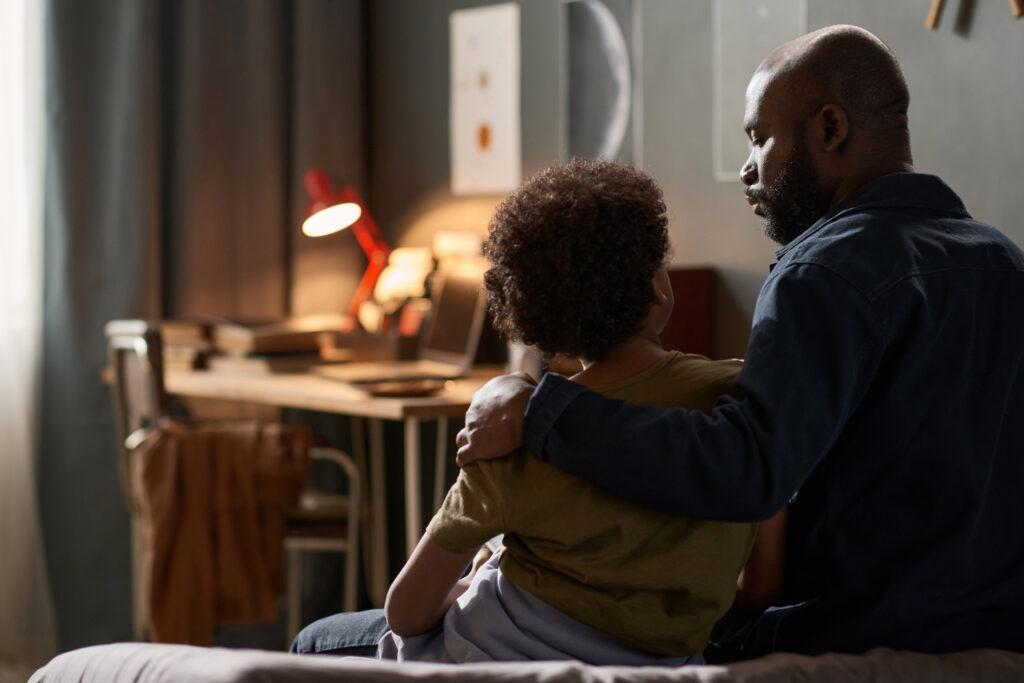 Back View Single Parent Embracing Son and Talking
