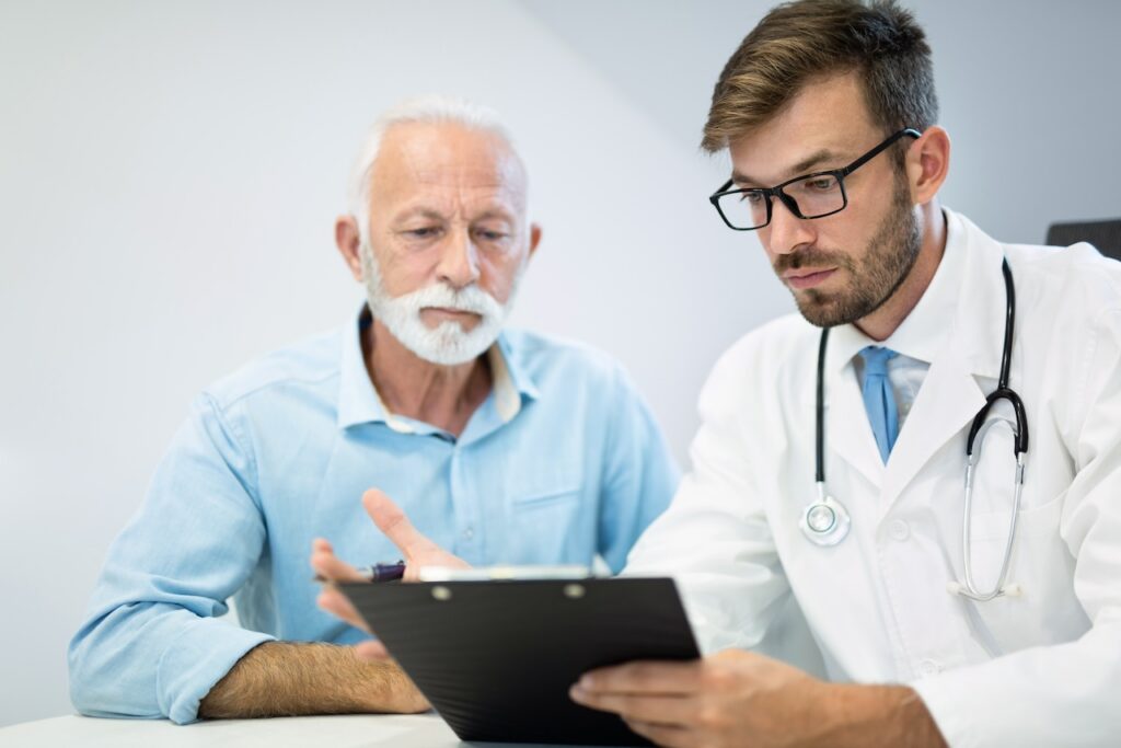 doctor and male senior patient looking at a medical record
