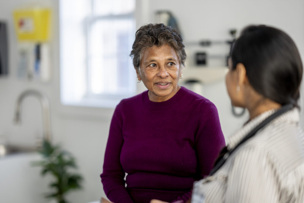 patient speaking with a female doctor in a bright clinic