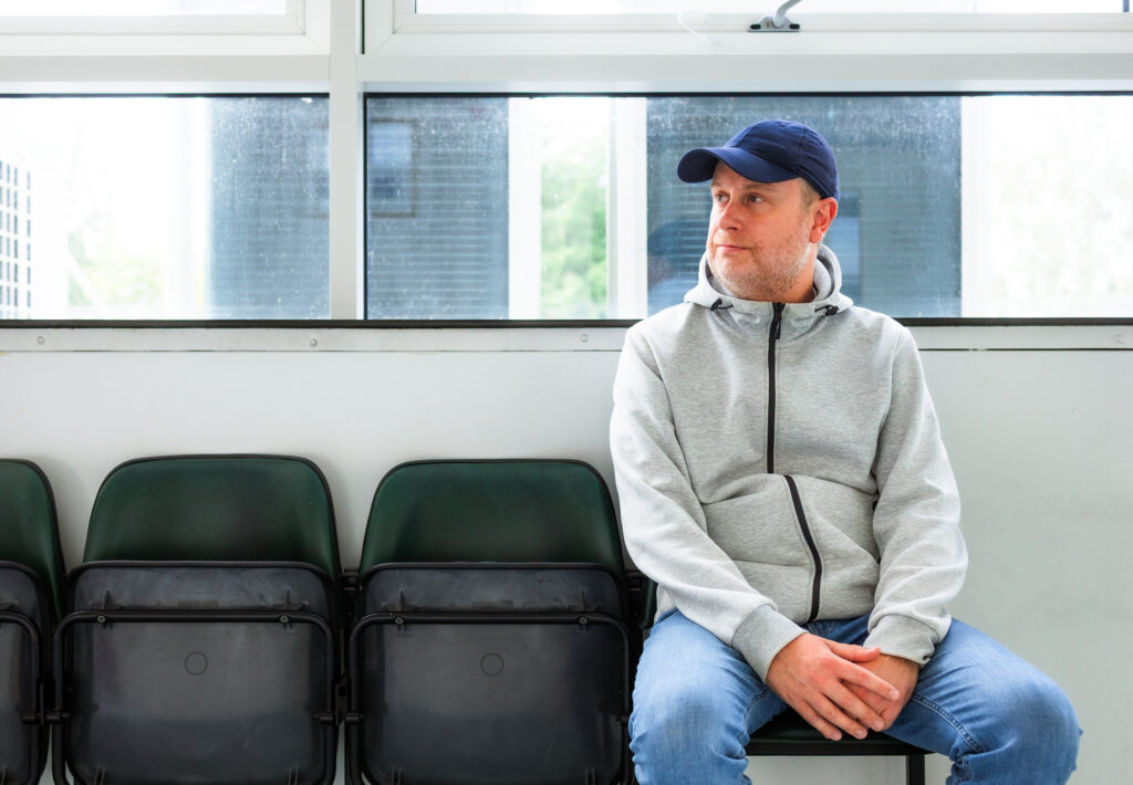 Male patient sitting in hospital waiting for appointment