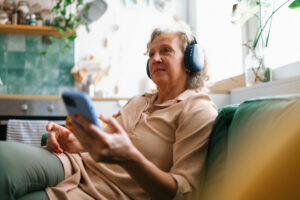 Woman listening to podcast at home
