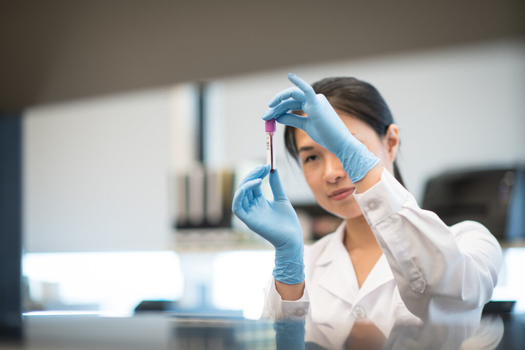 Female Laboratory Technician Checking a Blood Vial Sample stock photo