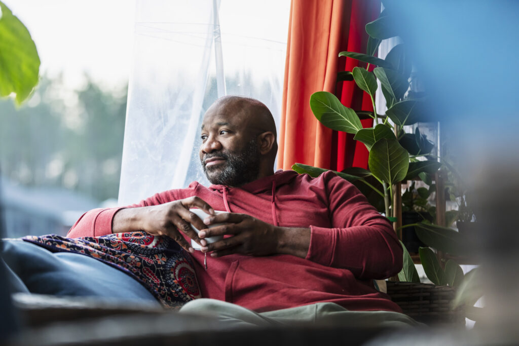 man relaxing at home, drinking tea