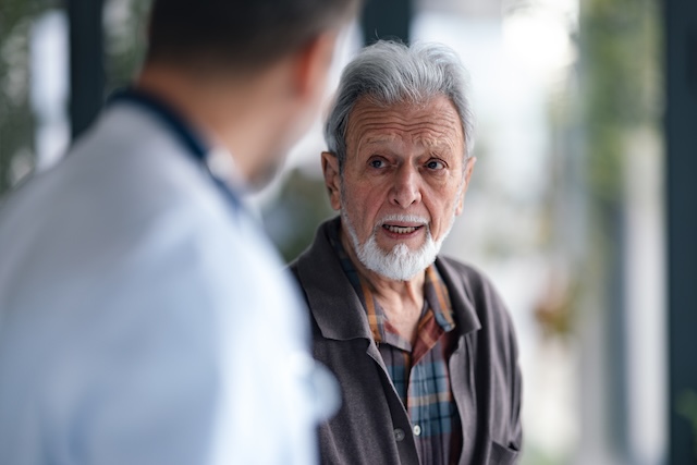 An elderly man speaks with a doctor in a calm, intimate moment of consultation. The scene conveys health care, trust, and concern, highlighting the patient-doctor relationship and the importance of medical guidance for seniors.