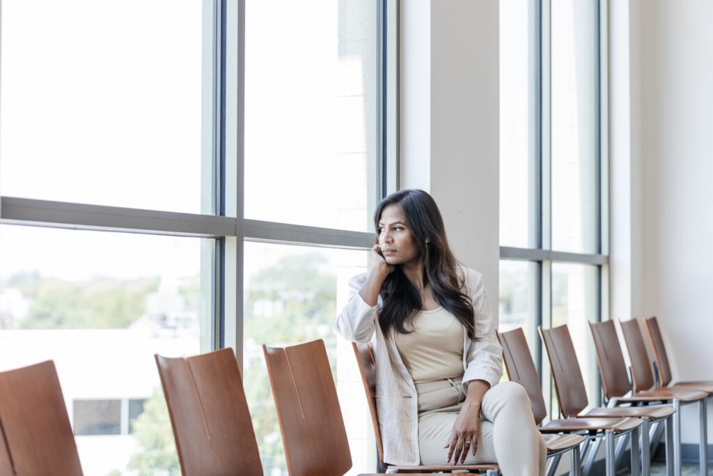 woman looks out window while waiting
